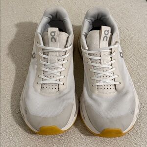 On Running Cream and Yellow Athletic Shoes